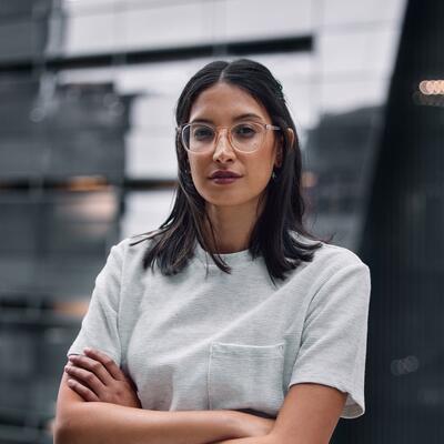 Junge Frau mit Brille blickt in die Kamera.