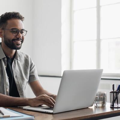 Kurzsichtiger junger Mann arbeitet am Computer