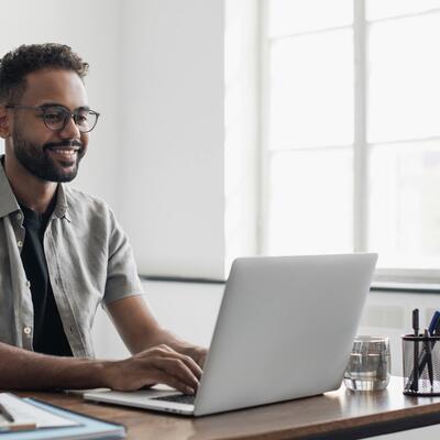 Kurzsichtiger junger Mann arbeitet am Computer