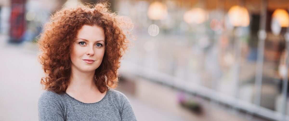 Junge Frau blickt ernst in die Kamera.